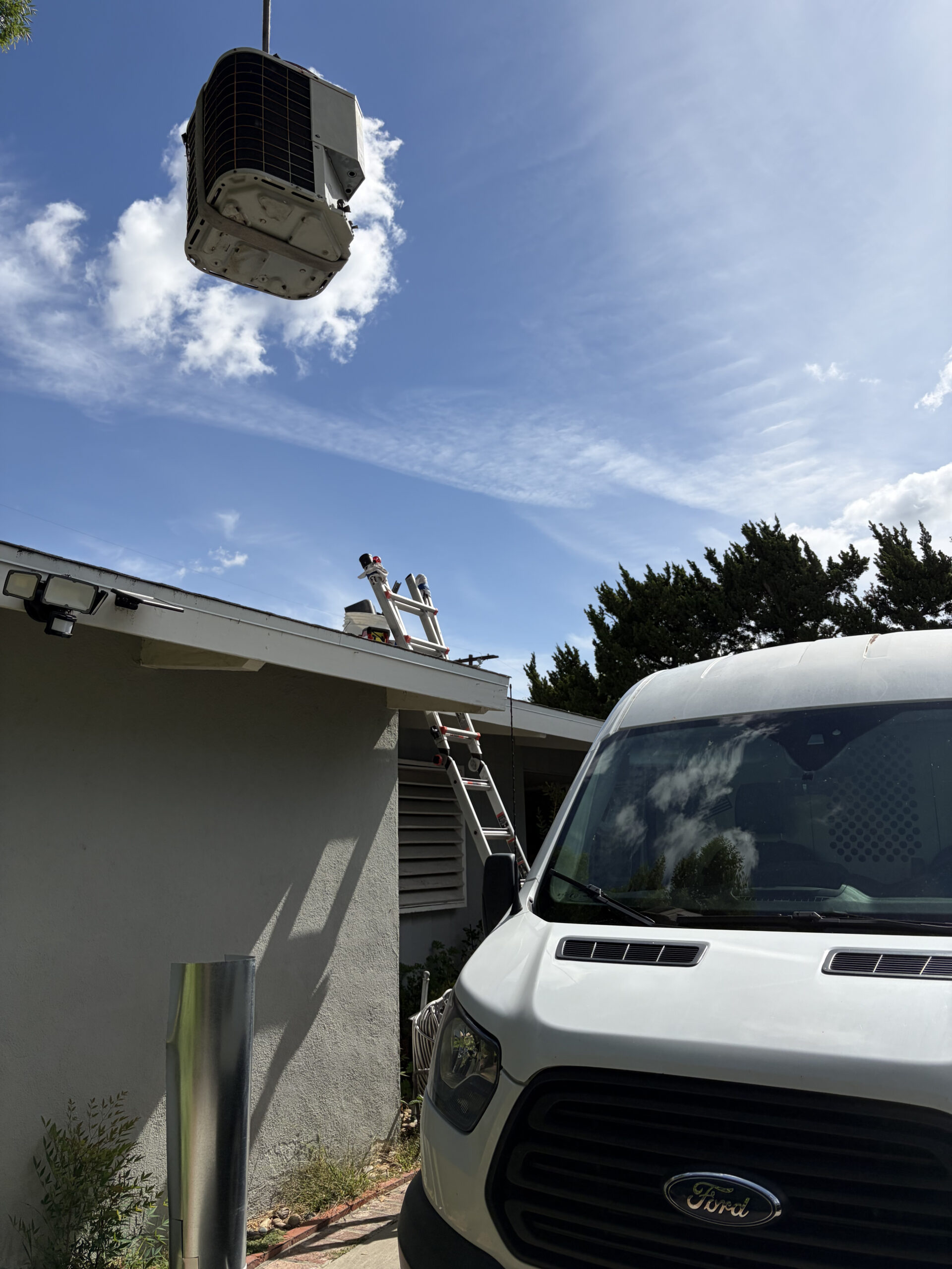 Technician diagnosing failed outdoor AC unit at a Thousand Oaks home during hot afternoon