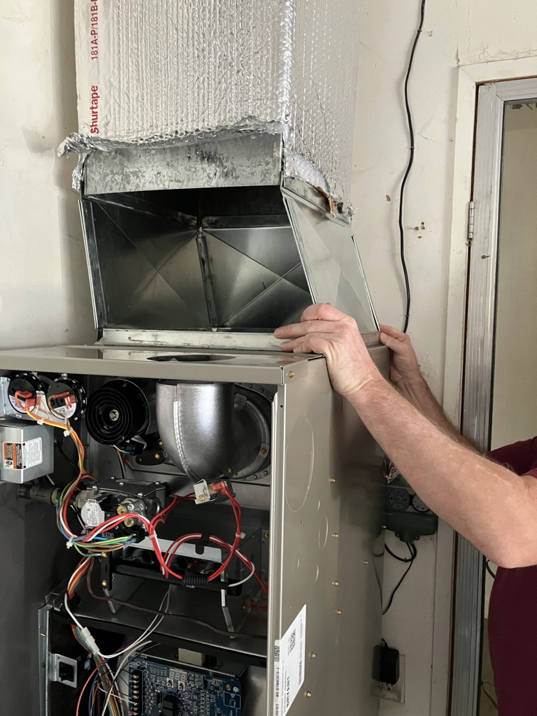 Experienced HVAC technician testing furnace controls and airflow with professional diagnostic tools