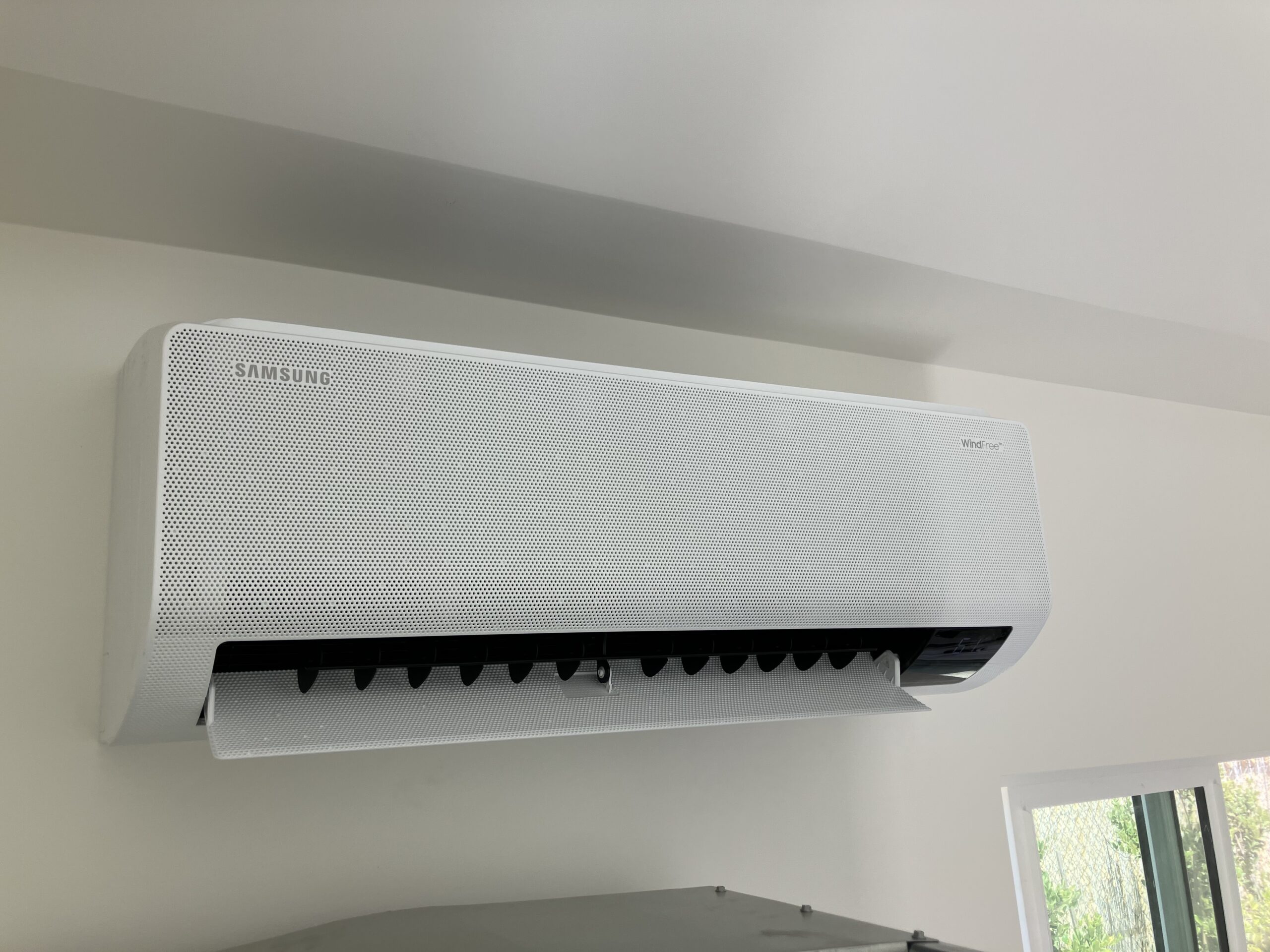 Mini split indoor unit installed above desk in renovated home office space