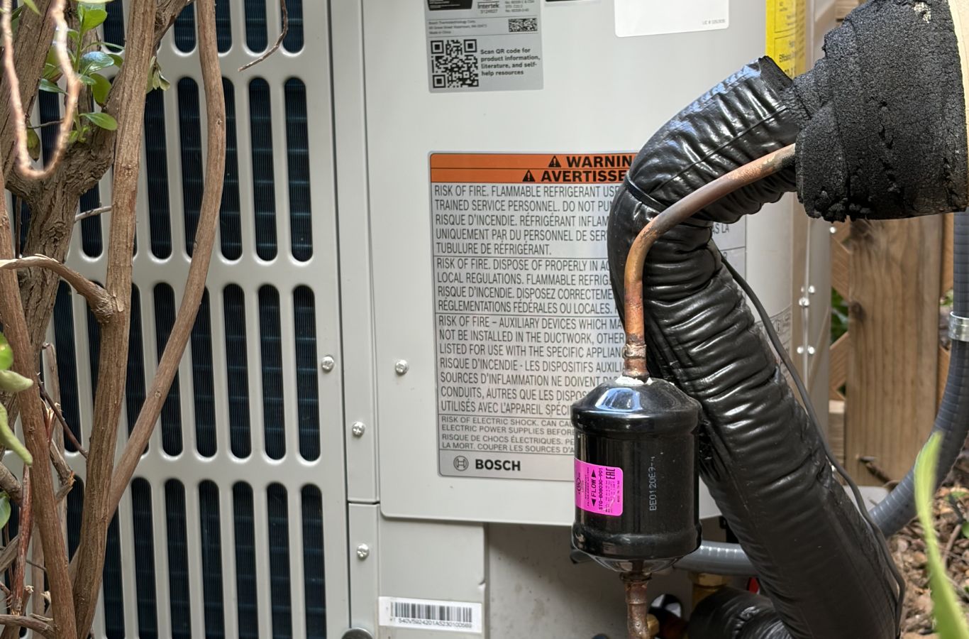 Technician diagnosing residential air conditioner issue during afternoon repair visit in Oxnard