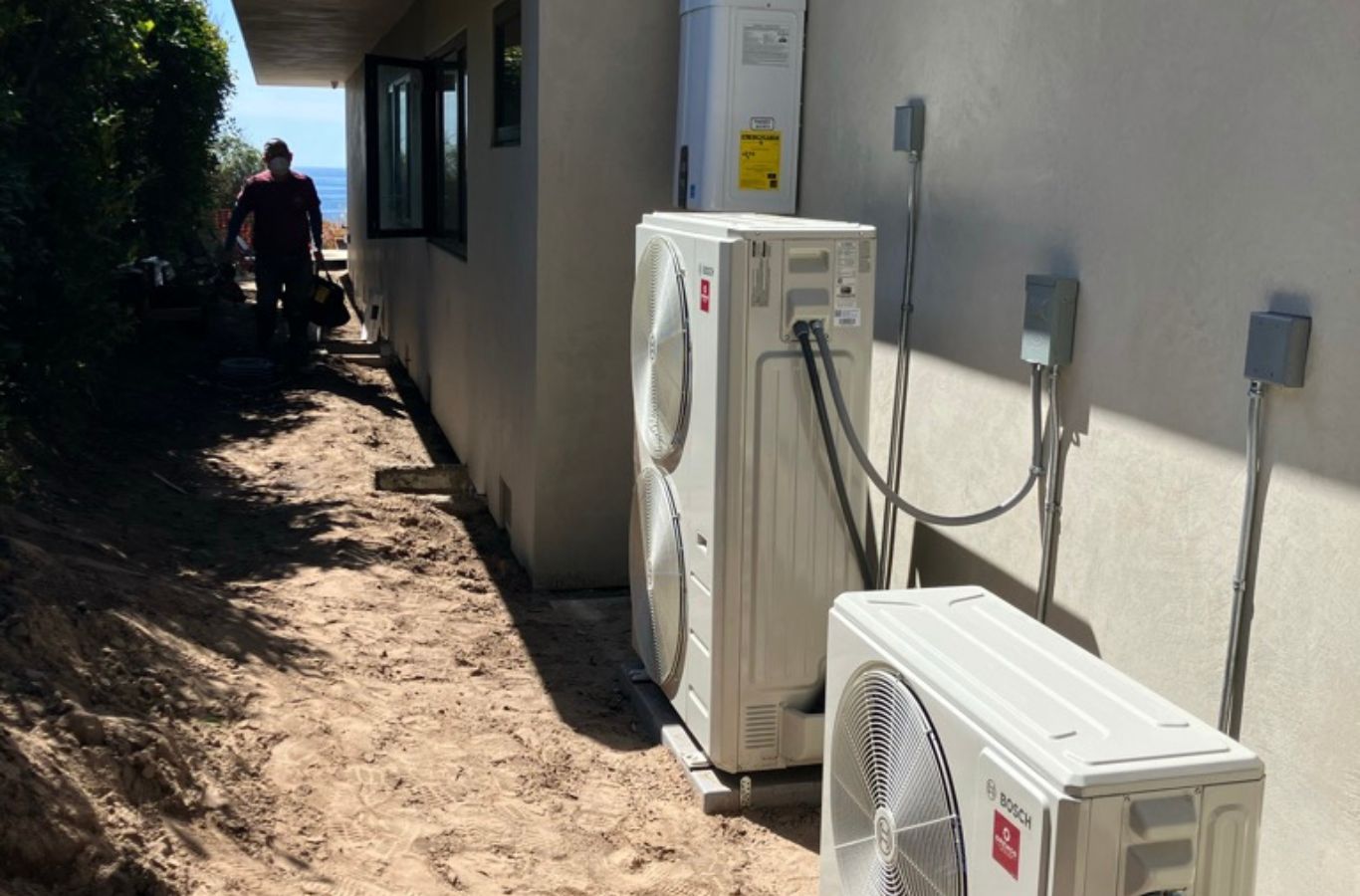 Technician diagnosing residential air conditioner failure outside Ventura home on warm day